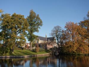 アルクマールにあるHoliday home in the centre of Alkmaarの木々のある川の横の家