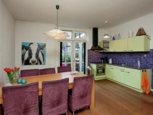 アルクマールにあるHoliday home in the centre of Alkmaarのキッチン(木製テーブル、紫色の椅子付)