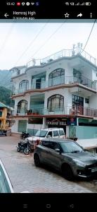 a car parked in front of a large building at Holiday Hill, Mcleodganj, Dharamsala in Dharamshala