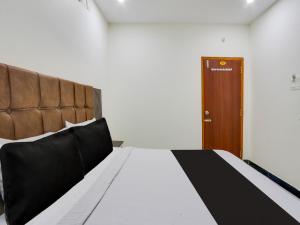 Super OYO Hotel Arjun Residency في Khammam: غرفة نوم بسرير وباب خشبي