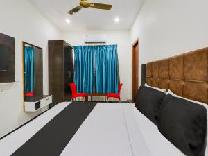 a bedroom with a bed and a red chair at Super OYO Hotel Arjun Residency in Khammam