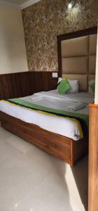 a large bed with a wooden frame in a room at Sky Pie hotel in Dharamshala