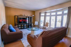 a living room with two couches and a tv at Beautiful 5 BDRM Home, Fenced Yard, WiFi, Fireplace, Free Parking, Transit, Town Centre - Sleeps 12 in Edmonton
