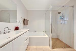Henley Beach SouthにあるHenley Hideawayのシャワーと洗面台を備えた白いバスルーム +41枚の写真
