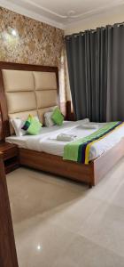 a bedroom with a large bed with green pillows at Sky Pie hotel in Dharamshala