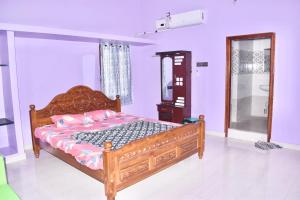 una camera con letto in legno e specchio di Sri Annamalaiyar Guest House a Tiruvannāmalai