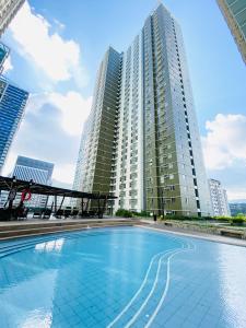 a large swimming pool in front of tall buildings at Cebu Avida Riala by P&J in Cebu City