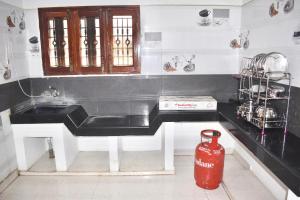 una cucina con lavandino e idrante rosso di Sri Annamalaiyar Guest House a Tiruvannāmalai