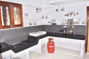 Sri Annamalaiyar Guest House في تيروفانمالي: مطبخ مع حنفية حريق حمراء يجلس بجوار كونتر