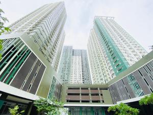 a tall white building with two tall buildings at Cebu Avida Riala by P&J in Cebu City