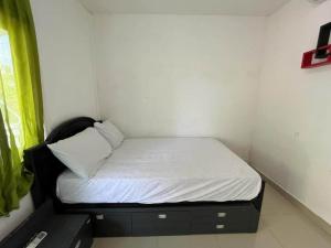 een klein bed in een kleine kamer met een raam bij OYO 93785 Aero Kost Bu Lisa Syariah in Lawang