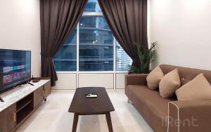 sala de estar con sofá y TV en Sky Suites KLCC by iRent365, en Kuala Lumpur