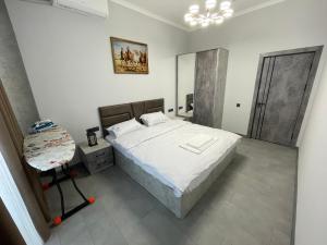 a bedroom with a large bed and a mirror at Art Hotel Navoiy in Navoi