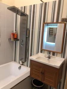 uma casa de banho com um lavatório, uma banheira e um espelho. em Furutech Resort em Malolos
