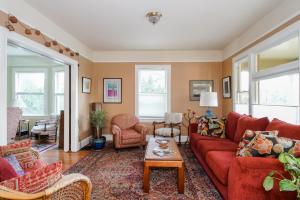 a living room with a red couch and chairs at Big beautiful house off Alberta—2 bdms sunny patio in Portland
