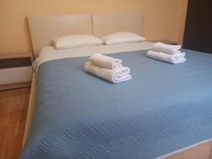 due asciugamani su un letto con coperta blu di Apartment Filipovic a Podgorica