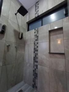uma casa de banho com um chuveiro e uma porta de vidro em Máster Suite Departamento cerca de Isla San Marcos em Aguascalientes