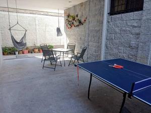 una mesa de ping pong y sillas en un patio en Máster Suite Departamento cerca de Isla San Marcos en Aguascalientes