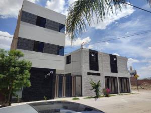 a white building with black windows on a street at Máster Suite Departamento cerca de Isla San Marcos in Aguascalientes