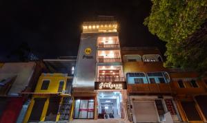 un edificio alto con un cartel en él por la noche en Itsy By Treebo - Prakasam Residency With Roadside View, en Pondicherry