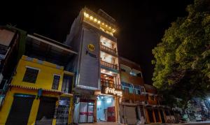 a tall building with lights on it at night at Itsy By Treebo - Prakasam Residency With Roadside View in Puducherry