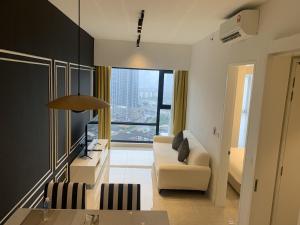 a living room with a white couch and a large window at Axon Suites KL Pavilion in Kuala Lumpur