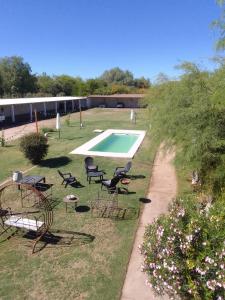 a yard with chairs and a swimming pool at Hotel Hualum in Villa Dolores