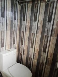 baño con aseo y pared de madera en Good for 15pax excess charge 350 per head, en Tagbilaran City