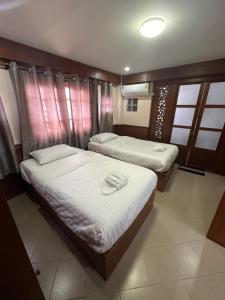 twee bedden in een kleine kamer bij Mona House Phuket in Ban Na Bon
