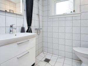 a white bathroom with a sink and a toilet at Holiday home Fanø VIII in Fanø