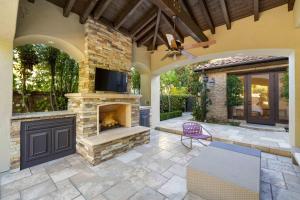 an outdoor patio with a fireplace and a tv at @ Marbella Lane - 4BR Mediterranean-style Home in Newport Beach