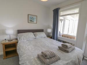 um quarto com uma cama com toalhas em Hafod-y-Gors em Fairbourne