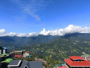 uma vista para uma cidade com montanhas ao fundo em LHONARK RESIDENCY em Gangtok