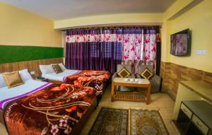 ein Hotelzimmer mit 2 Betten und einem Fenster in der Unterkunft LHONARK RESIDENCY in Gangtok