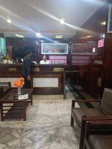 eine Person, die am Tresen eines Restaurants steht in der Unterkunft LHONARK RESIDENCY in Gangtok