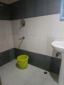 a bathroom with a yellow bucket and a sink at LHONARK RESIDENCY in Gangtok