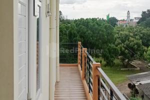 a balcony of a building with a view of trees at Asyura Kostel Syariah Redpartner in Kedaton