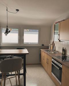 a kitchen with a table and two windows and a sink at Ferienwohnung Rebblick in Müllheim