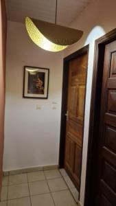 um corredor com uma porta de madeira e um lustre em Prestige Spa Cayenne T2 em Cayenne