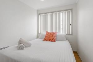 a bedroom with a white bed with a window at 2-Bed Unit with Balcony BBQ & Stunning Lake Views in Belconnen