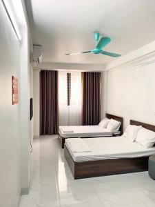 a bedroom with two beds and a ceiling fan at GRAD Minh Trang Motel in Hanoi