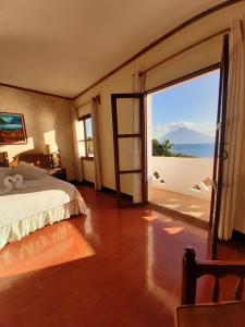 a bedroom with a bed and a view of the ocean at Tzanjuyu Youth Resort in Panajachel