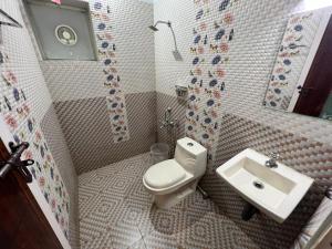 a bathroom with a toilet and a sink at Confident Residency in Guruvāyūr