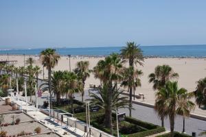 Una vista de una playa con palmeras y el océano. en Almar 52 Suites, en Valencia