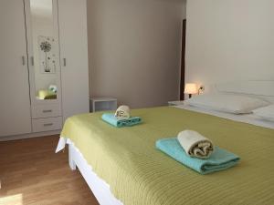 sypialnia z łóżkiem i ręcznikami w obiekcie Apartments Sonija w mieście Gdinj