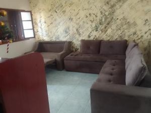 a living room with a brown couch and a window at Casa espaçosa no Bethânia in Ipatinga