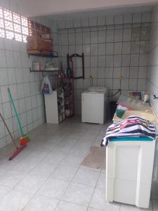 een kamer met een tegelvloer, een wastafel en een bad bij Casa espaçosa no Bethânia in Ipatinga