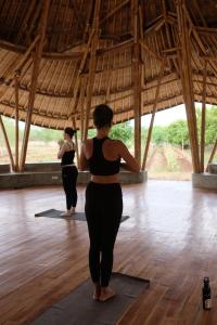 two women standing in a yoga pose in a room at Maringi Sumba by Sumba Hospitality Foundation in Waikelo