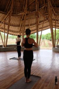Waikelo的住宿－Maringi Sumba by Sumba Hospitality Foundation，两个站在瑜伽室的女人摆着一个姿势
