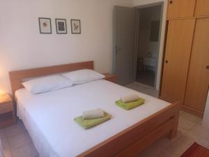 een slaapkamer met een wit bed en 2 handdoeken bij Apartments Sonija in Gdinj